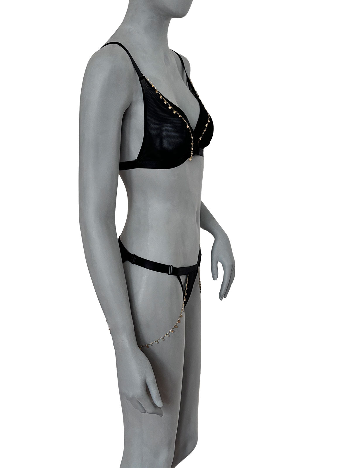 Sutiã Emma preto em tule transparente com correntes banhadas em ouro 18k e pingentes dourados, decote profundo triangular, alças finas ajustáveis, vista lateral em manequim fundo neutro, lingerie sem bojo confortável design autoral Cisô Atelier.