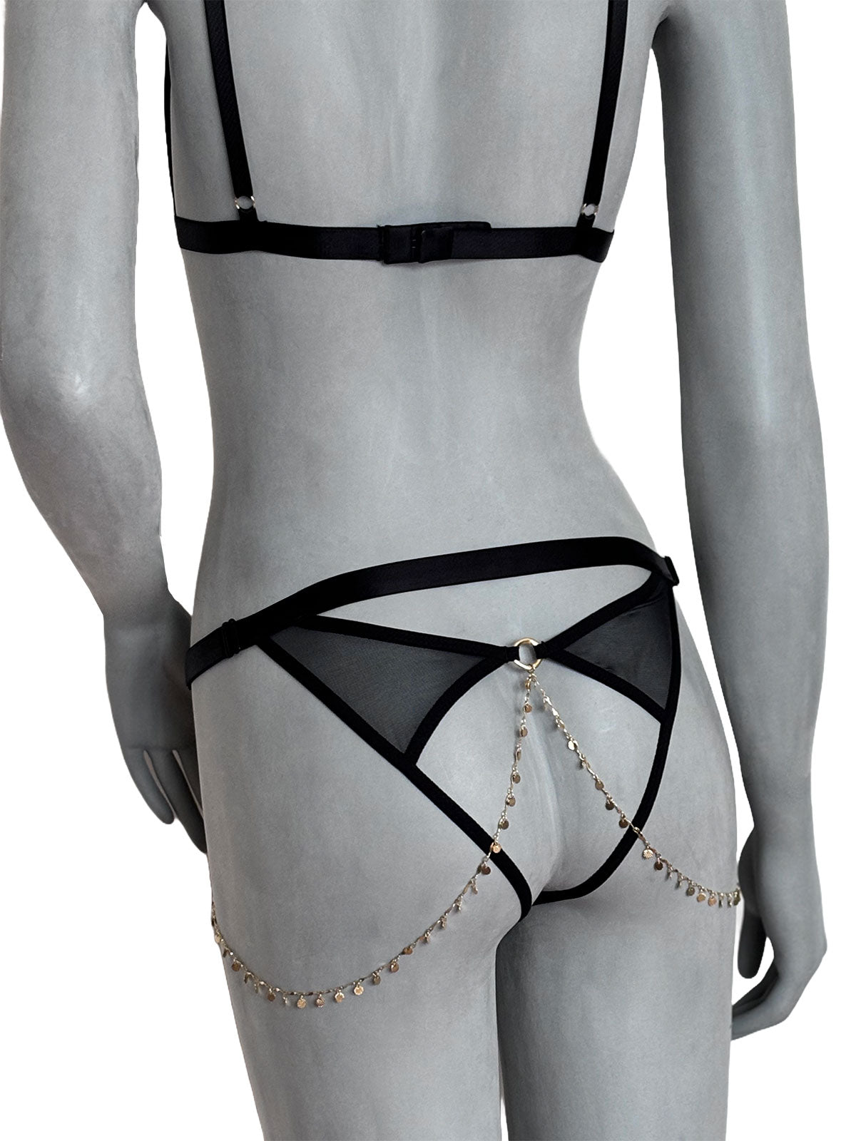 Conjunto lingerie Emma Cisô Atelier com sutiã preto e calcinha com corrente de ouro 18k, vista de costas no manequim cinza claro
